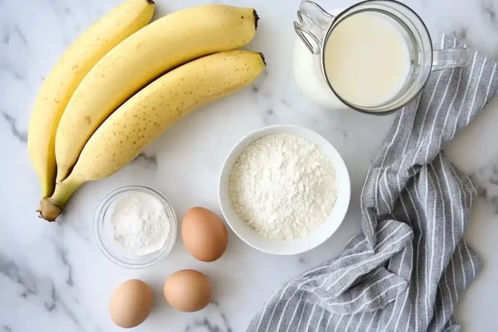 Ingredients for banana pancakes on white marble